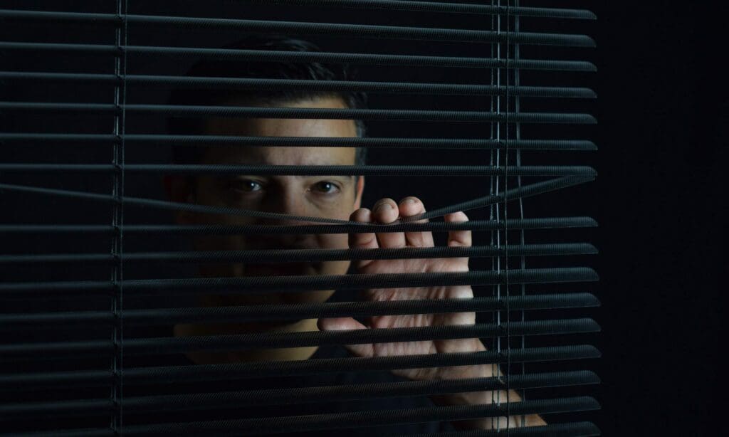 Mann hinter Jalousien