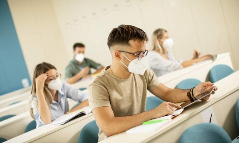 Studenten mit Masken im Hörsaal — boggy22 / depositphotos